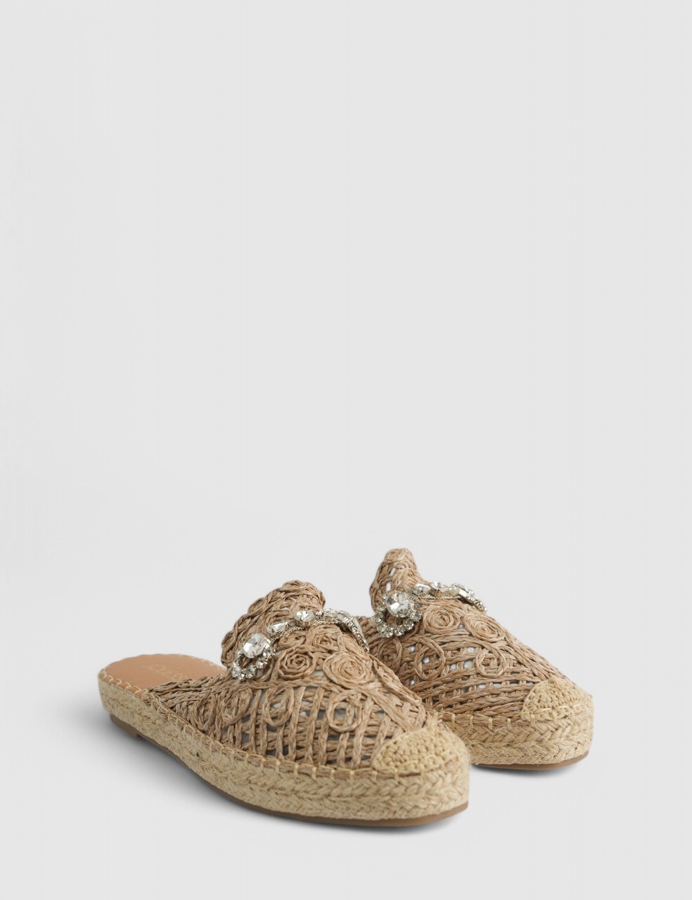 Cette image contient Mules raphia avec détails bijoux chez Joliesse. à 62,99 TND en Tunisie. L'hexa de l'arrière plan est #E7E7E