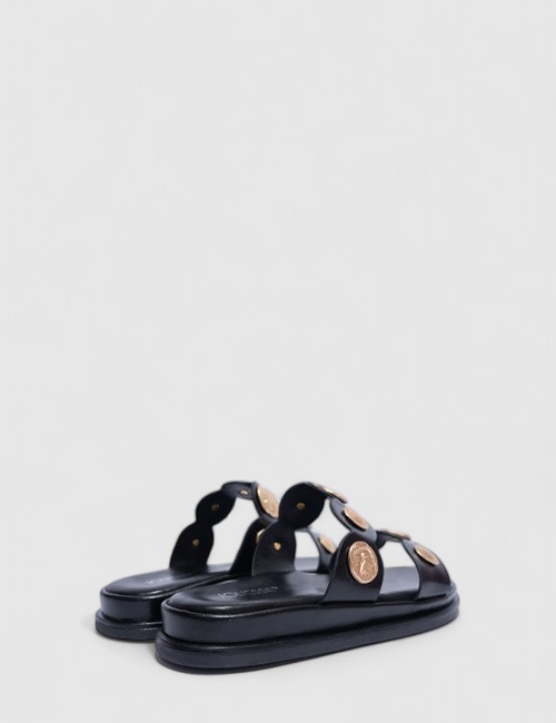 Cette image contient Mules Plates Noires avec Ornements Métalliques chez Joliesse. à 0,00 TND en Tunisie. L'hexa de l'arrière pl