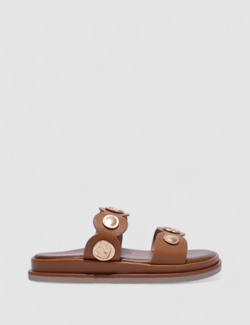 Cette image contient Mules Plates Noires avec Ornements Métalliques chez Joliesse. à 0,00 TND en Tunisie. L'hexa de l'arrière pl