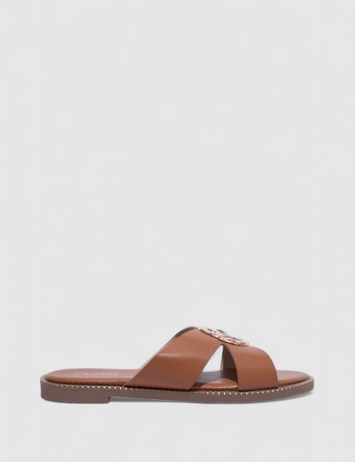 Cette image contient Mules Plates en Cuir Cognac avec Ornements chez Joliesse. à 59,99 TND en Tunisie. L'hexa de l'arrière plan 