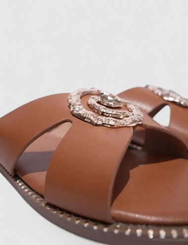 Cette image contient Mules Plates en Cuir Cognac avec Ornements chez Joliesse. à 59,99 TND en Tunisie. L'hexa de l'arrière plan 