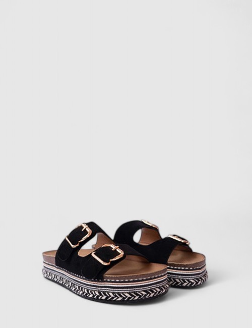 Cette image contient Mules noires à brides ajustables chez Joliesse. à 79,99 TND en Tunisie. L'hexa de l'arrière plan est #E7E7E