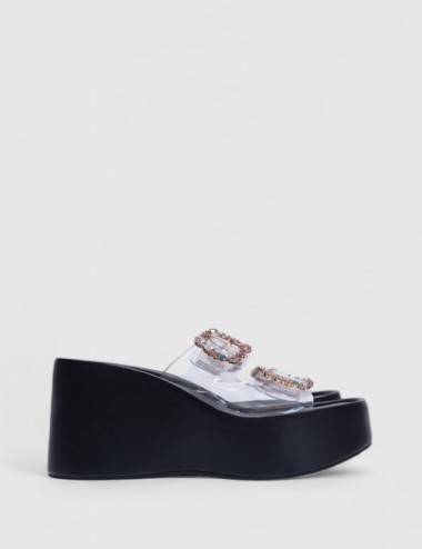 Cette image contient Sandales compensées transparentes avec strass multicolores chez Joliesse. à 99,99 TND en Tunisie. L'hexa de