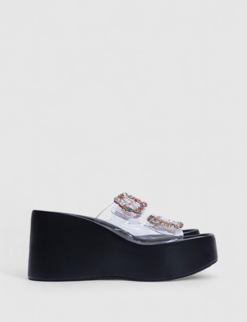 Cette image contient Sandales compensées transparentes avec strass multicolores chez Joliesse. à 99,99 TND en Tunisie. L'hexa de
