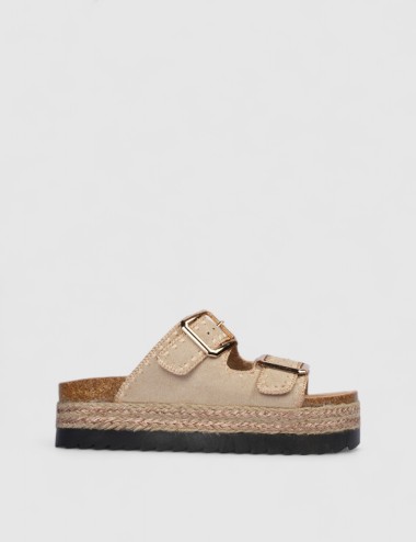 Cette image contient Mules en suédine beige avec boucles dorées chez Joliesse. à 0,00 TND en Tunisie. L'hexa de l'arrière plan e