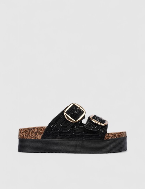 Cette image contient Mules noires brillantes avec boucles dorées chez Joliesse. à 0,00 TND en Tunisie. L'hexa de l'arrière plan 