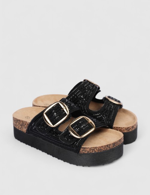 Cette image contient Mules noires brillantes avec boucles dorées chez Joliesse. à 0,00 TND en Tunisie. L'hexa de l'arrière plan 