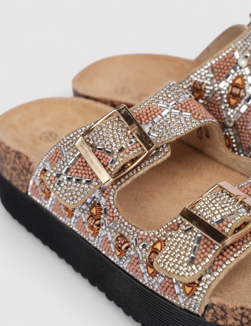 Cette image contient Mules femme motif ethnique strass et boucles dorées chez Joliesse. à 0,00 TND en Tunisie. L'hexa de l'arriè