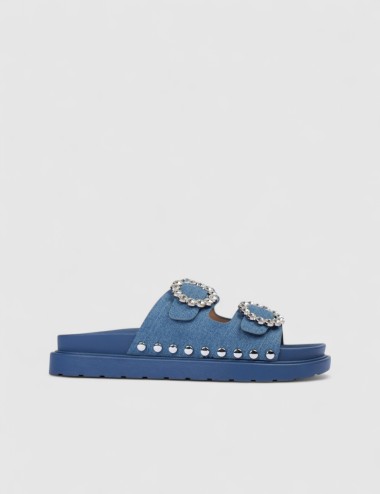 Cette image contient Mules denim bleu à boucles strass et semelle épaisse chez Joliesse. à 0,00 TND en Tunisie. L'hexa de l'arri