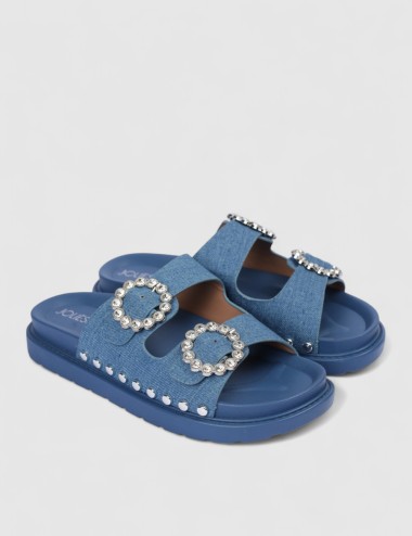 Cette image contient Mules denim bleu à boucles strass et semelle épaisse chez Joliesse. à 0,00 TND en Tunisie. L'hexa de l'arri