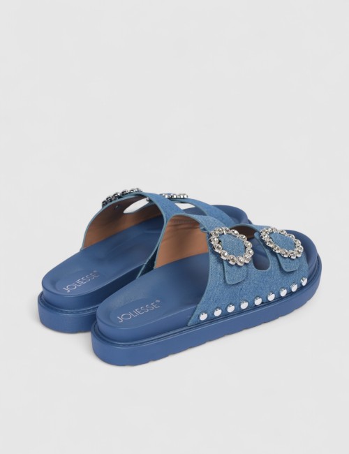 Cette image contient Mules denim bleu à boucles strass et semelle épaisse chez Joliesse. à 0,00 TND en Tunisie. L'hexa de l'arri