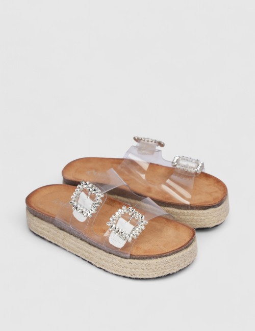 Cette image contient Mules transparentes à boucle brillante et semelle corde chez Joliesse. à 0,00 TND en Tunisie. L'hexa de l'a