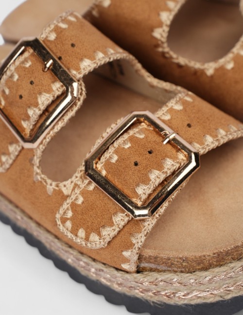 Cette image contient Mules en suédine beige avec boucles dorées chez Joliesse. à 84,99 TND en Tunisie. L'hexa de l'arrière plan 
