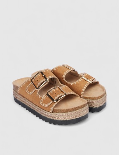 Cette image contient Mules en suédine beige avec boucles dorées chez Joliesse. à 84,99 TND en Tunisie. L'hexa de l'arrière plan 