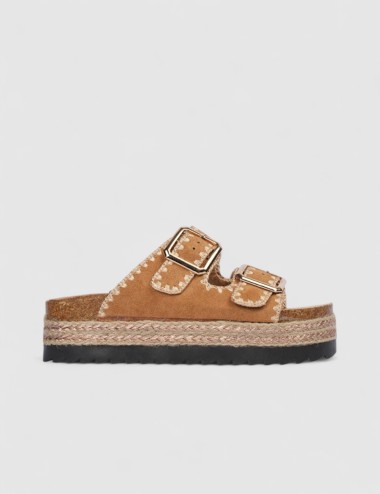 Cette image contient Mules en suédine beige avec boucles dorées chez Joliesse. à 84,99 TND en Tunisie. L'hexa de l'arrière plan 