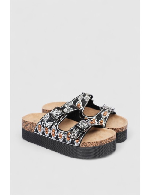 Cette image contient Mules femme motif ethnique strass et boucles dorées chez Joliesse. à 79,99 TND en Tunisie. L'hexa de l'arri
