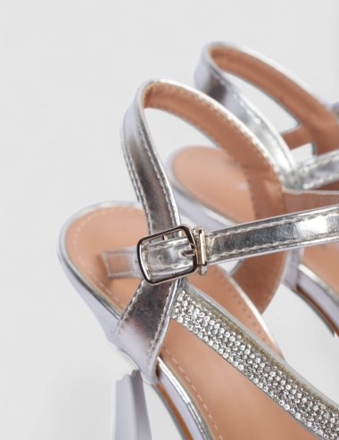 Cette image contient Sandales argentées à talons hauts avec strass chez Joliesse. à 0,00 TND en Tunisie. L'hexa de l'arrière pla