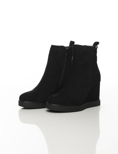 Cette image contient Bottines compensées noires en suédine chez Joliesse. à 169,99 TND en Tunisie. L'hexa de l'arrière plan est 