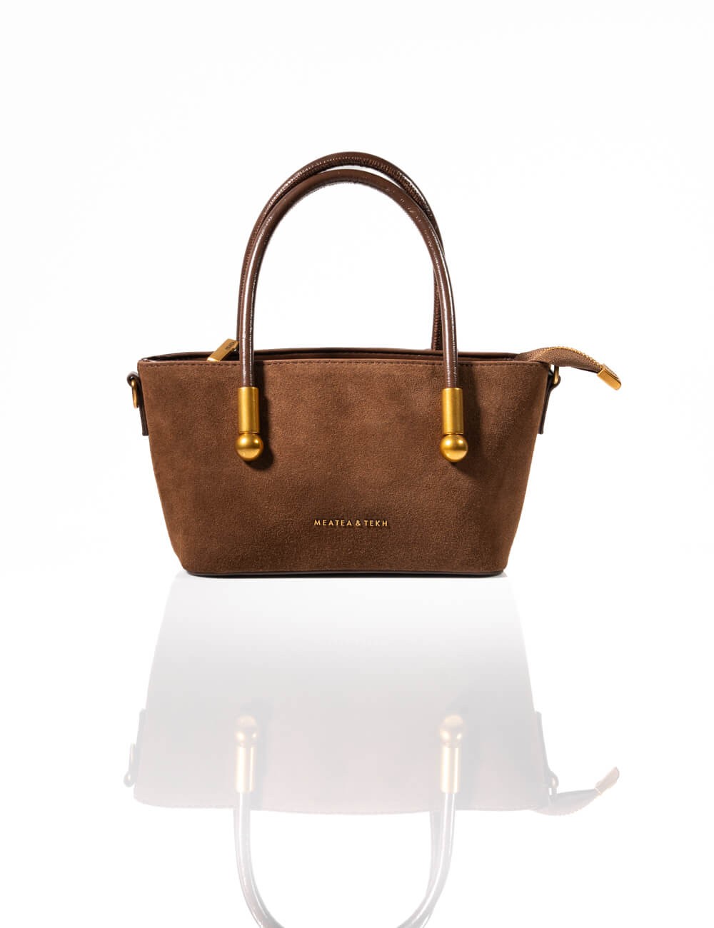 Cette image contient Sac à Main en Daim Marron avec Pompon chez Joliesse. à 129,99 TND en Tunisie. L'hexa de l'arrière plan est 